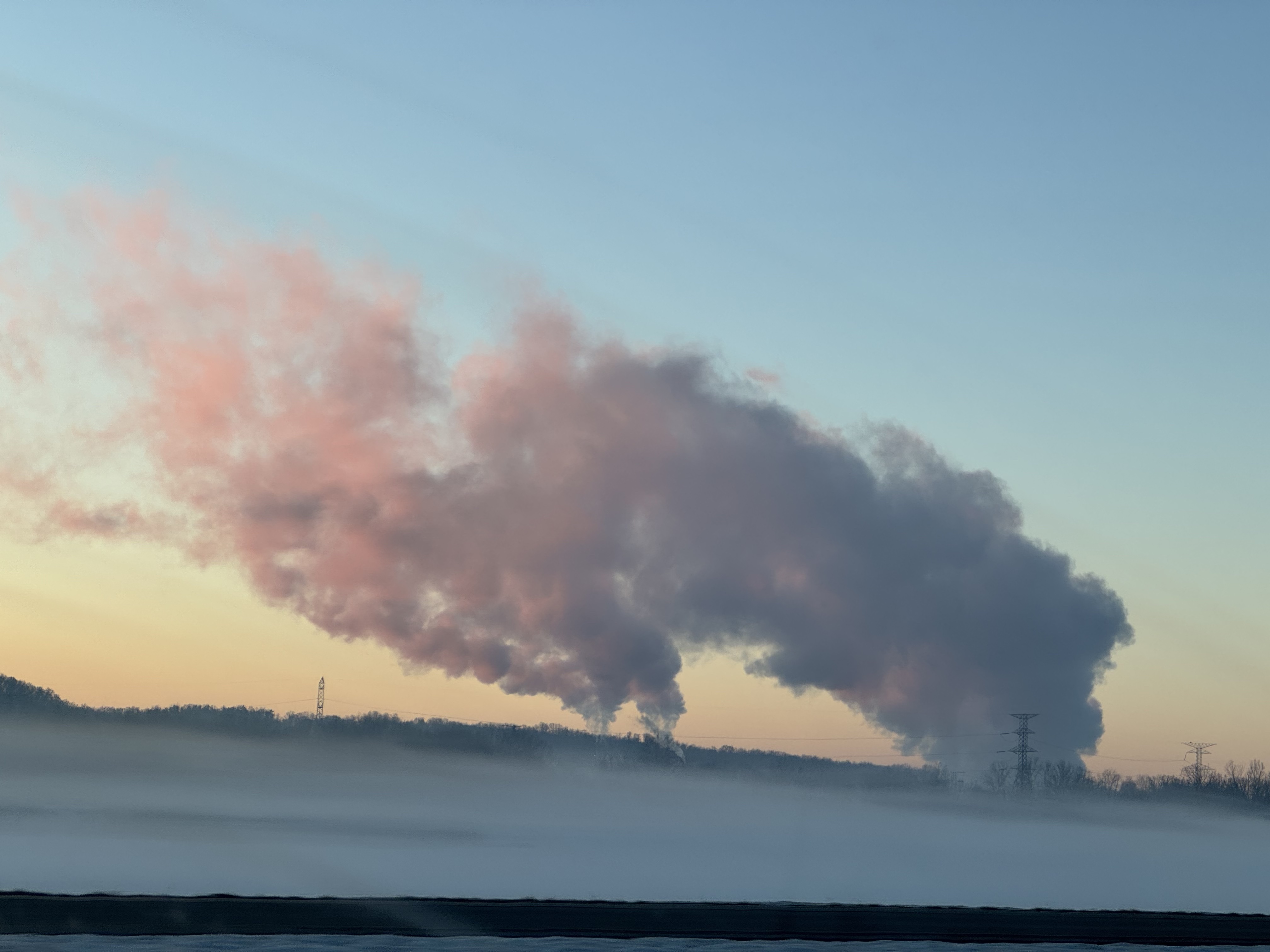 Picture of pink and purple smoke against a yellow and blue sunrise